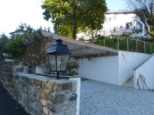 a lamp on a stone wall next to a building at Dorre Pean in Ciboure