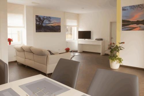 een woonkamer met een bank en een televisie bij Ferienwohnung Seetalblick in Geiselberg