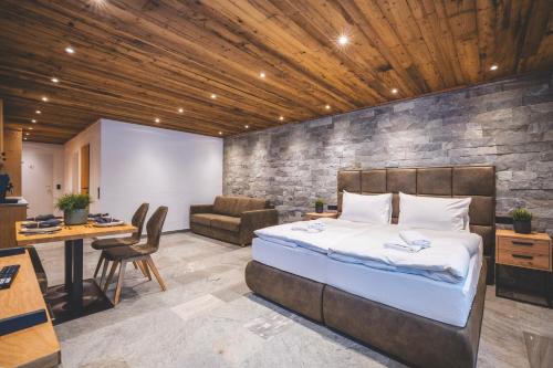 a bedroom with a bed and a desk and a chair at Alpine Essence - Luxury Apartment in Zell am See Center in Zell am See