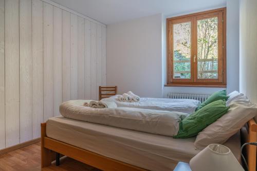 a large bed in a room with a window at Surgiva del Sòm in Folgaria