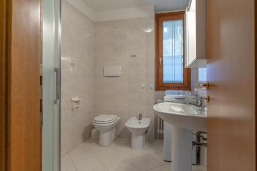 a bathroom with a toilet and a sink at Surgiva del Sòm in Folgaria