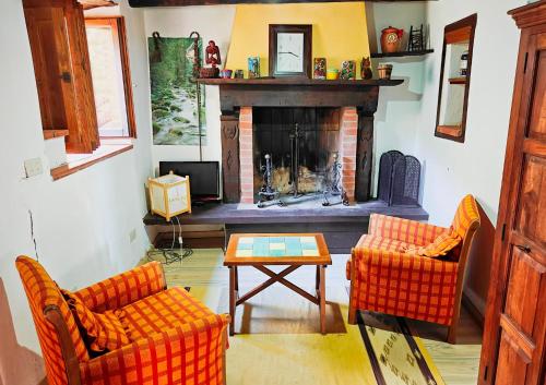 un soggiorno con due sedie e un camino di Casa Rosa a Vetriano