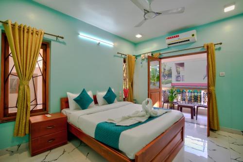 a bedroom with a large bed and a window at Hotel Eyokar Goa in Candolim