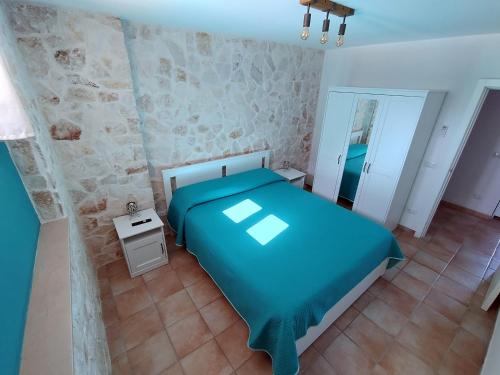 a bedroom with a blue bed and a mirror at Alba e Colori di Puglia in Conversano