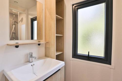 a bathroom with a sink and a window at Camping Clos Cottet in Angles