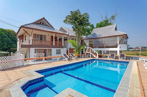 a swimming pool in front of a house at The Galvis Pool Villa - Boutique Stay Near Na Jomtien Beach in Na Jomtien
