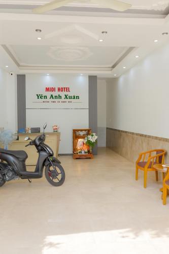 a scooter parked in a room with a sign on the wall at Yến Ánh Xuân Hotel in Phan Rang–Tháp Chàm