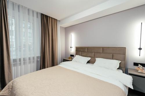 基希讷乌Urban Elegance的一间卧室，配有一张大床和一扇窗户。