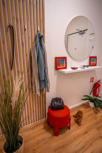 a room with a red ottoman and a mirror at Sweet Embrace in Brno