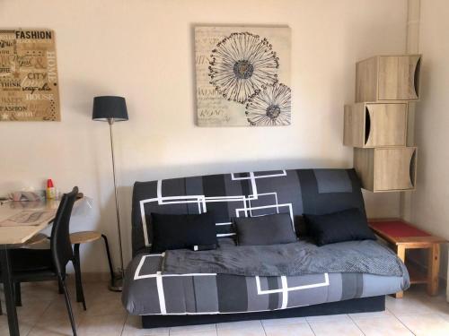 a bedroom with a bed and a table and a desk at Au petit bonheur in Calvisson