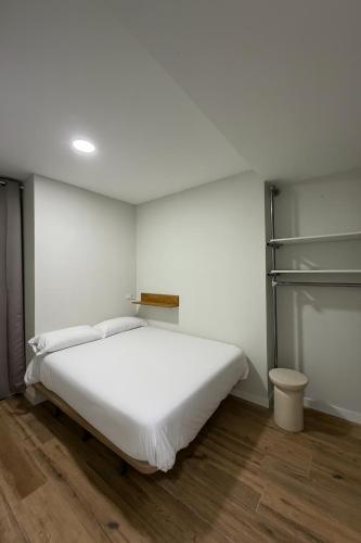 a bedroom with a white bed and a closet at Hostal Alcorcón in Alcorcón