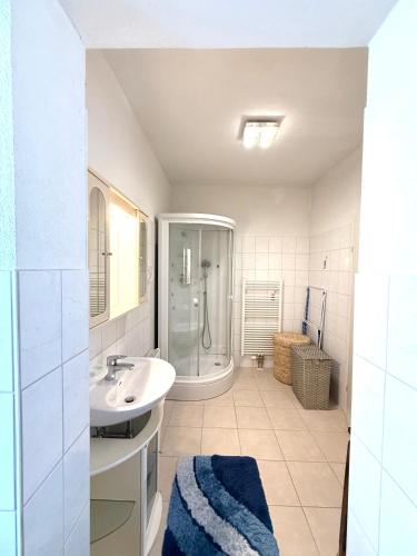 a white bathroom with a sink and a shower at Traumhafte Wohnung auf Pferde Ranch in Aich