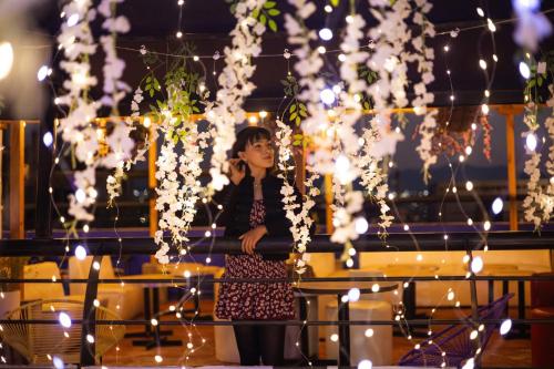 a woman standing in front of a table with lights at Villa Catrina in Morelia