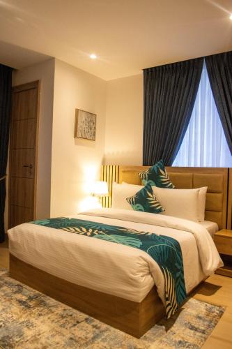 a bedroom with a large bed and a window at Orbit Apartments in Lagos