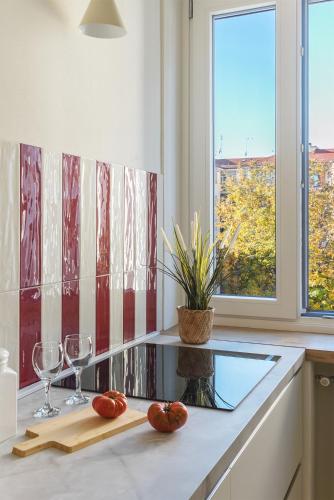 a kitchen with two wine glasses and tomatoes on a counter at La Bice in Savigliano