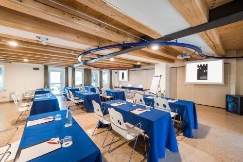a conference room with blue tables and white chairs at Hotel Veronesi La Torre in Dossobuono