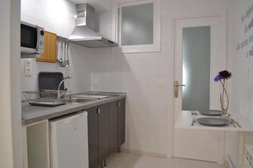 cocina blanca con fregadero y encimera en Minimal Apartamentos, en Tudela