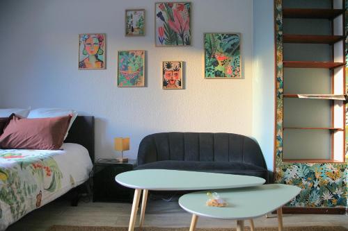 ein Schlafzimmer mit einer Couch, einem Tisch und einem Bett in der Unterkunft L'Atelier des Tropiques in Saverne