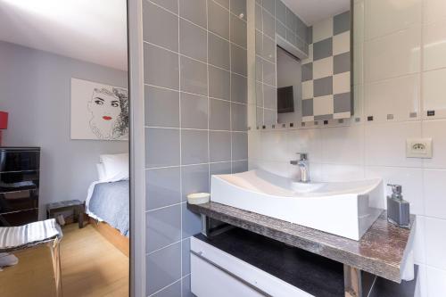 a bathroom with a white sink and a bedroom at Les Villas De Mandelieu in Mandelieu-La Napoule