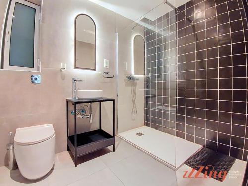 a bathroom with a toilet and a sink and a shower at South 32 Hotel by Zzzing in Birżebbuġa