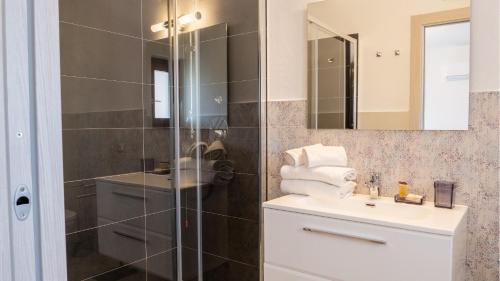 a bathroom with a shower and a sink and a mirror at Samar in San Teodoro