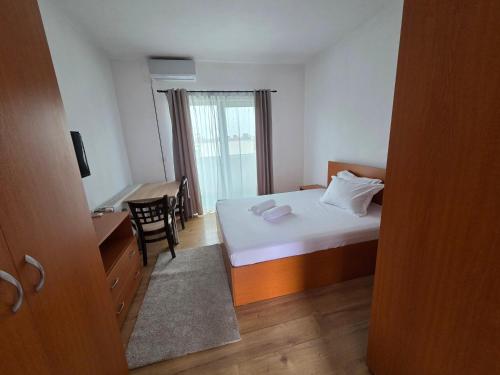 een slaapkamer met een bed, een bureau en een tafel bij Apartament DOM in Moşniţa Nouă