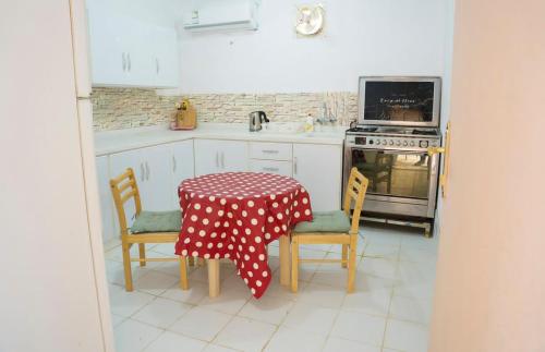 a kitchen with a table and two chairs and a stove at مزرعة أبو رامي ملعب كرة قدم ومسبح وألعاب مائية ومجالس واسعة in Al Kharj