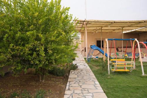 a backyard with a playground and a swing at مزرعة أبو رامي ملعب كرة قدم ومسبح وألعاب مائية ومجالس واسعة in Al Kharj