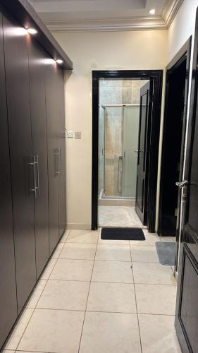 a hallway with a walk in shower and a glass door at مسكن الهجرة in Medina