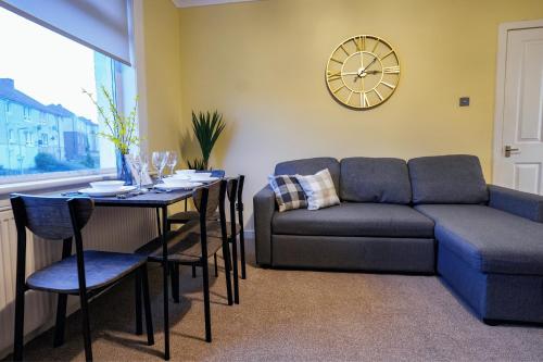 a living room with a couch and a table at West Apartment in Coatbridge