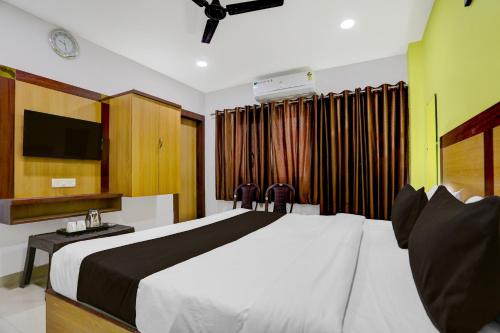 Hotel O Varanasi Trade Center formerly Vairaghi Villa في فاراناسي: غرفة نوم بها سرير كبير وتلفزيون