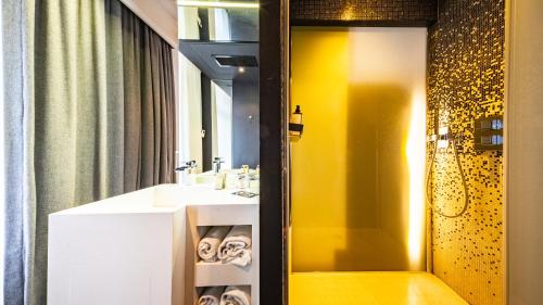 a bathroom with a sink and a shower at Vertigo Hotel, By Marriott, a Member of Design Hotels in Dijon
