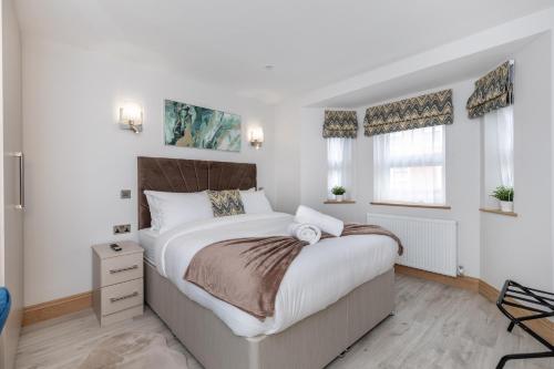 a bedroom with a large bed and two windows at Stanley House in Reading
