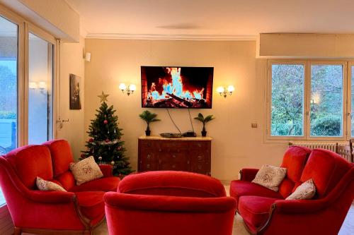 a living room with red chairs and a christmas tree at Clos de la Gare in Tournan-en-Brie