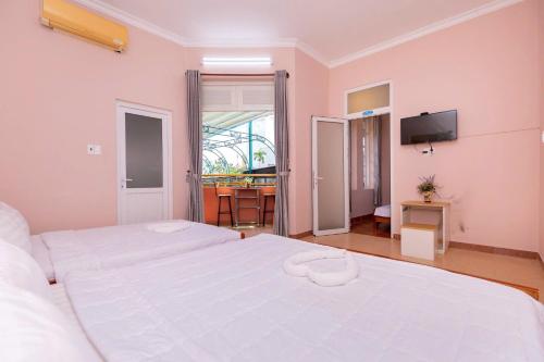 Un dormitorio con una gran cama blanca y un televisor. en Savara Homes Garden City, en Vung Tau