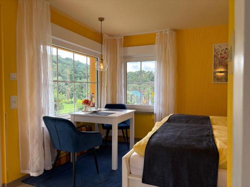 een slaapkamer met een bed, een bureau en een raam bij Ferienwohnung und -haus am Rennsteig bei Eisenach - Angela Jaentsch in Wolfsburg-Unkeroda