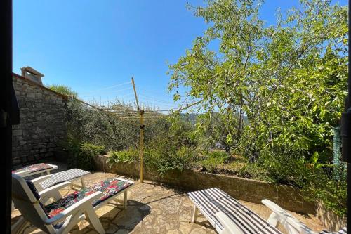 Provençal farmhouse 6 guests Peymeinade near Cannes في Peymeinade: فناء مع كرسيين وطاولة مطلة