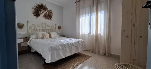 Una habitación blanca con una cama y una ventana en Mi Recreo - Casa Rural en Murcia, en Ojós
