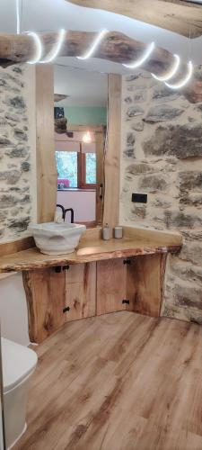 a bathroom with a wooden counter in a stone wall at Haraneko Errota Burdindegi in El Cerco