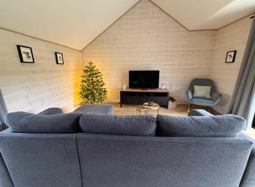 un soggiorno con un divano blu e un albero di Natale di Ambiance boisée Moustier a Stoumont