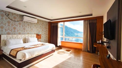 a bedroom with a large bed and a large window at The Z Retreat & Spa - Swimming Pool & Free Parking - Near Tashi ViewPoint in Gangtok