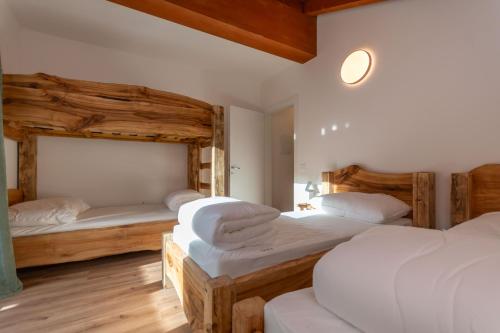 een slaapkamer met twee bedden met witte lakens bij Hapina Dolomiti in Cencenighe