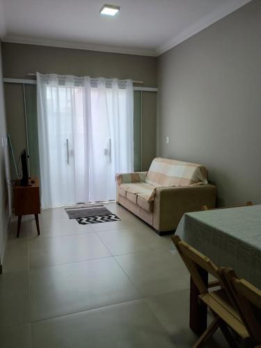 ein Wohnzimmer mit einem Bett und einer Couch in der Unterkunft Casa bananeira in Bombinhas