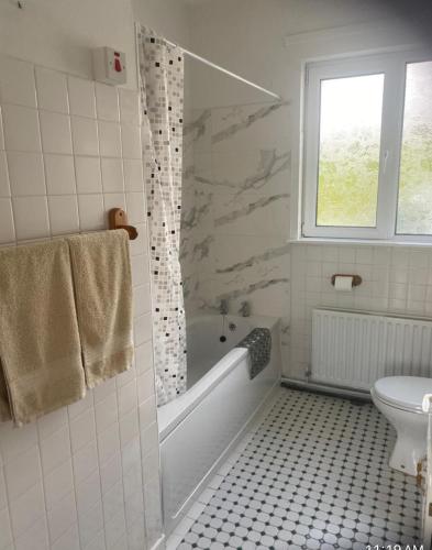 a bathroom with a tub and a toilet and a window at Harkins Haven in Mountcharles