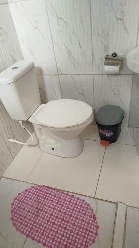 a bathroom with a toilet and a purple rug at hospedagem de ze maninha in Lençóis