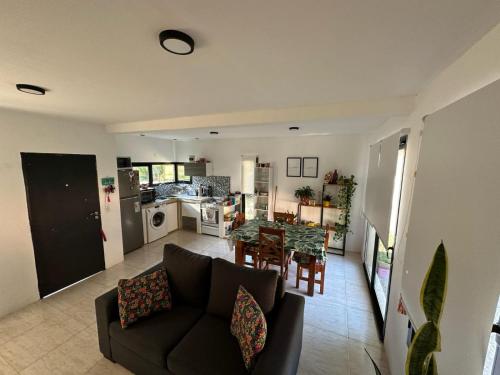 Una sala de estar y una cocina con un sofá y una mesa. en Casa con Patio y Parrilla Zona Golf, en Villa Gesell
