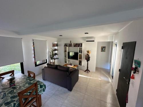 una sala de estar con un sofá y una mesa en Casa con Patio y Parrilla Zona Golf, en Villa Gesell