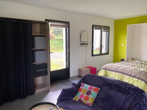 La PASSUITIÈRE في Saint-Mesmin: غرفة نوم بها سرير وأريكة ونافذة