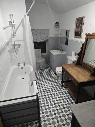 a bathroom with a tub and a toilet and a sink at Rose Cottage in Telford