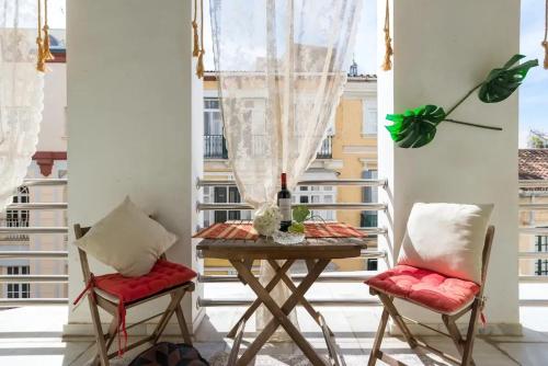 a table and two chairs on a balcony with a window at Charming Apartment in Malaga - 70 m² with Balcony in Málaga